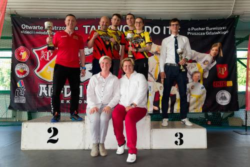 Zdjęcie przedstawia zwycięczów z pruszańskiego klubu AN-DO na podium z trenerem i organizatorkami zawodów.